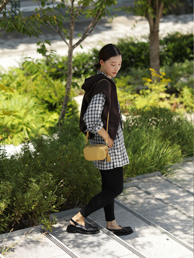 A person walking on a path surrounded by greenery, wearing casual clothing.